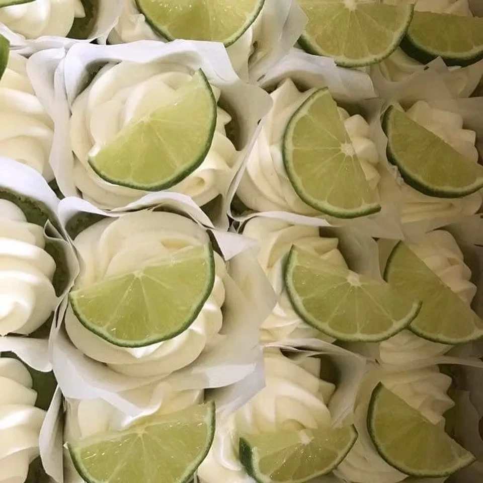 Key lime cupcakes with white frosting and lime slices